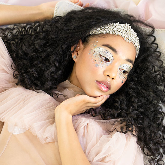 Glitter Prom Makeup on Reclining Model Wearing Evan Clayton Design