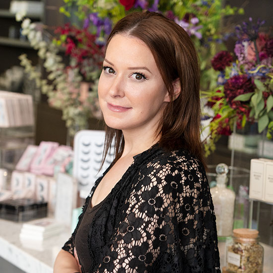 Trish standing in curliQue store in front of fresh flowers