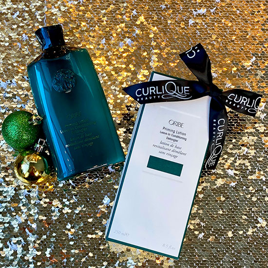 Christmas ornaments and Oribe priming lotion on glittery fabric
